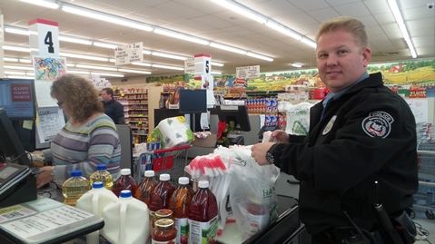 Happy Foods grocery store at 5420 Leavenworth Road today provided groceries for two families as a Christmas gift. The Leavenworth Road Association asked Community Policing officers to recommend some families for the gift. Officers Lightfoot and Parker accompanied the families and learned the art of sacking groceries. Happy Foods gives groceries to a family every Christmas season. (Photos by Lou Braswell)