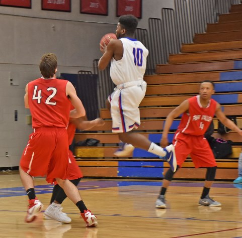 KCKCC freshman Mike Lee soars between three Penn Valley defenders for a driving layup in the Blue Devils’ come-from-behind 75-68 win over the Scouts Tuesday night. (KCKCC photo by Alan Hoskins) 