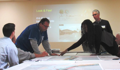 The moderator, Triveece Penelton, right, who is with a firm that is conducting the public meetings and study of the K-32 corridor, pointed to an area on the map at Tuesday night’s meeting at the Grinter barn. (Staff photo by Mary Rupert)