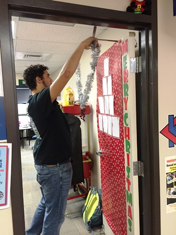 Vice president of the Student Senate at KCKCC, Lansing graduate Joe Lendway used his 6-6 size to help in the door decorating contest at Christmas at the College. (KCKCC photo)