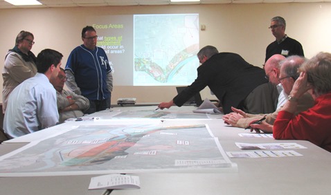 The moderator, Triveece Penelton, right, who is with a firm that is conducting the public meetings and study of the K-32 corridor, pointed to an area on the map at Tuesday night’s meeting at the Grinter barn. (Staff photo by Mary Rupert)