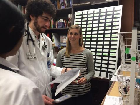 Maddy Breedan, right, a student at the University of Kansas School of Medicine, talked about patient treatment with fellow student Adam Stizmann at the JayDoc Free Clinic.  (Photo by Alex Smith/Heartland Health Monitor)