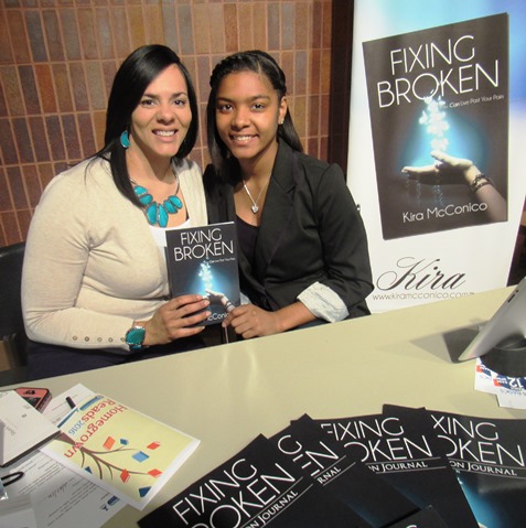 Kira McConico, left, author of "Fixing Broken," held her book at the Homegrown Reads program Saturday at the West Wyandotte Library. With her was her daughter, Mereiah McConico. (Photo by Mary Rupert)