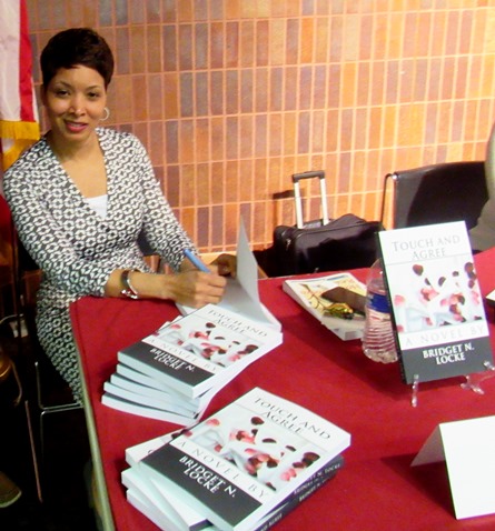 Bridget N. Locke signed a copy of her first book, "Touch and Agree," for a reader on Saturday at the Homegrown Reads program at the West Wyandotte Library. (Photo by Mary Rupert)