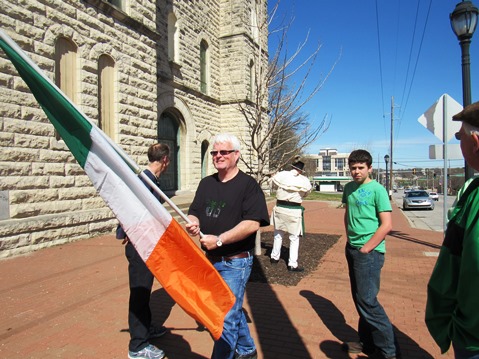 Bob Kennedy held the Irish flag as a very small group gathered on the sidewalk of St. Mary's Church at 5th and Ann to start the annual Kansas City, Kan., St. Patrick's walk down 5th Street. (Staff photo)