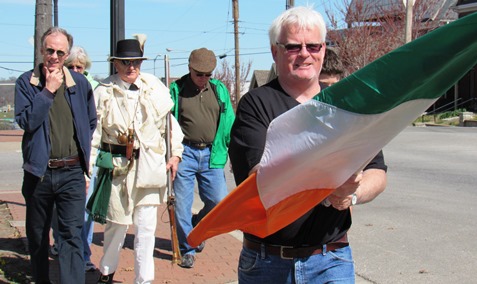 Bob Kennedy held the Irish flag as a very small group gathered on the sidewalk of St. Mary's Church at 5th and Ann to start the annual Kansas City, Kan., St. Patrick's walk down 5th Street. (Staff photo)