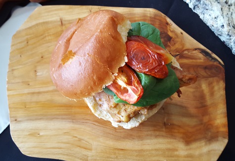 The smoked chicken sandwich takes the chicken sandwich to new levels. It layers a cherry wood-smoked chicken thigh with grilled tomato, roasted garlic aioli and baby spinach on fresh bolillio roll. (Photo by William Crum)