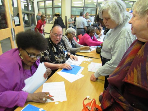 Volunteers checked names at a registration table at the 4th DIstrict Democratic caucus on Saturday at KCKCC-TEC, 65th and State Avenue, Kansas City, Kan.  (Staff photo)