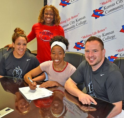 Surrounded by, from left, KCKCC assistant coaches Chamissa Anderson and Dawn Owens and head coach Joe McKinstry, a happy Erin Anderson signed a letter of intent to continue her basketball career at Missouri Western University. (KCKCC photo by Alan Hoskins) 