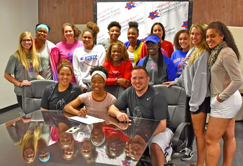 Flanked by KCKCC assistant coaches Chamissa Anderson, left, and head coach Joe McKinstry and her national championship teammates, Erin Anderson signed a letter of intent to continue her basketball career at Missouri Western University. (KCKCC photo by Alan Hoskins) 