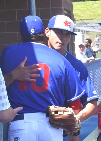 Righthander Brandon Reid gets a congratulatory hug from assistant coach Elliot Velaquez after his 2-hit pitching performance gave KCKCC a 13-0 win over Barton County in opening round playoff action Saturday. (KCKCC photo by Alan Hoskins)