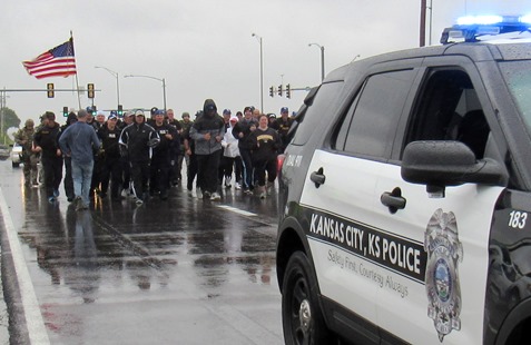 A cold, slow rain fell this morning as members of the Kansas City, Kan., Police Department ran a 1.4-mile stretch in full tactical gear on 118th in honor of slain Detective Brad Lancaster. Members of the Kansas City Kan., Police Department’s Special Operations Unit and other tactical units participated in the run, which started near where a vehicle was carjacked and traced a route to where he was killed, near the Hollywood Casino in Kansas City, Kan. The tactical team plans to do this run each year on May 9 in Detective Lancaster’s memory. (Staff photo) 