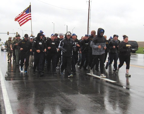 A cold, slow rain fell this morning as members of the Kansas City, Kan., Police Department ran a 1.4-mile stretch in full tactical gear on 118th in honor of slain Detective Brad Lancaster. Members of the Kansas City Kan., Police Department’s Special Operations Unit and other tactical units participated in the run, which started near where a vehicle was carjacked and traced a route to where he was killed, near the Hollywood Casino in Kansas City, Kan. The tactical team plans to do this run each year on May 9 in Detective Lancaster’s memory. (Staff photo) 