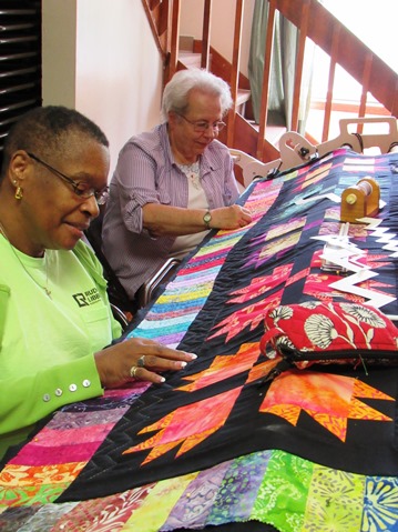 Two members of the Grinter Quilters, Albertha Martin, left, and Patsy Wiebrecht, worked on the 2016 opportunity quilt, a very colorful bear paws pattern. The quilt is a fundraiser for Grinter Place.  (Staff photo by Mary Rupert)