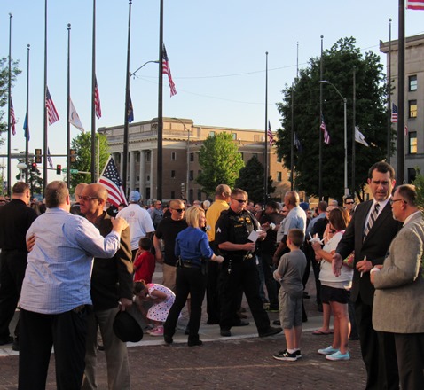 Kansas Attorney General Derek Schmidt and Wyandotte County District Attorney Jerome Gorman, on the far right, talked before the candlelight event started. State Sen. David Haley, on the left, also was in attendance. Flags flew at half-staff.  (Staff photo)