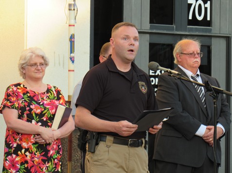 Officer Dustin Dierenfeldt, center, sang "Amazing Grace" during the candlelight vigil. (Staff photo)