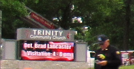 A sign for Detective Brad Lancaster's visitation on Friday evening at Trinity Community Church. A flag flew at a visitation on Friday evening for Detective Brad Lancaster at Trinity Community Church, Kansas City, Kan. (Photo by a community member)