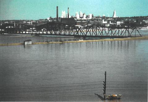 Railroad bridge - The Kaw River was out of its banks in this view from Strawberry Hill in Kansas City, Kan., during the 1951 flood. The bridge belonged to the Kansas City Southern Railroad. The smoke stacks in the background are from the Armour meat packing plant. The downtown Kansas City, Mo., skyline can be seen in the far background.  (Photo courtesy of the Wyandotte County Museum)  