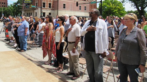 Those attending saluted the flag at a memorial dedication today at the Wyandotte County Courthouse lawn. (Staff photo)