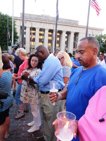 Residents and colleagues held candles at the vigil Wednesday night in front of City Hall. Flags flew at half-staff. (Staff photo by Mary Rupert)