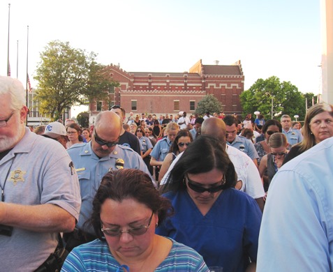 The crowd paused for a prayer at the candlelighting vigil Wednesday night for Capt. Robert David  Melton at Kansas City, Kan., City Hall. (Staff photo by Mary Rupert)