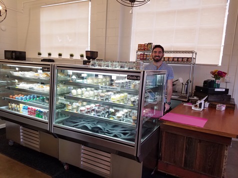 Alex Gilgus, an employe, was behind the counter of the Kansas City Cupcake Co. earlier this week. It recently opened a location at 6th and Ann. (Photo by William Crum) 