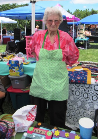 Nadine Vogts of Wyandotte County displayed an apron she sewed at the Grinter Summerfest Saturday at 78th and K-32. The free event continues until 4 p.m. (Staff photo)