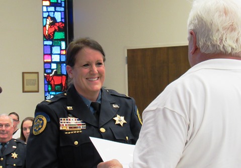 Stephen Barnhart awarded a presidential certificate to Lt. Kelli Bailiff of the Wyandotte County Sheriff's Department for her volunteer service on Thursday night at the Unified Government Commission meeting. (Staff photo by Mary Rupert)