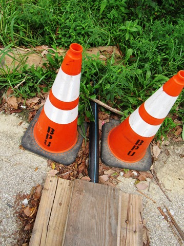 A board across North 50th Terrace temporarily carries water to the neighborhood, but a resident says she has had a flat tire from having to drive over it.