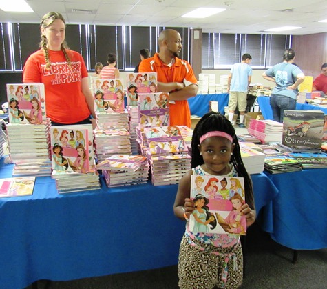 A student displays a Disney Princess book she received from the Kansas City, Kan., Public Library table. (Staff photo)