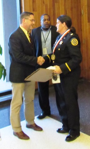 Mayor Mark Holland, left, congratulated Lt. Kelli Bailiff on her award after the UG meeting on Thursday night. UG spokesman Edwin Birch is in the background. (Staff photo)