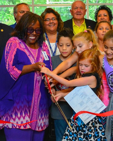 Kansas City, Kan., Board of Education Vice President Brenda Jones, assisted by members of the Frank Rushton Elementary School Student Council, cut the ribbon at the dedication of new school building on Sept. 13.  Board members Richard Kaminski and Irene Caudillo looked on. (Photo by Brian Turrel)