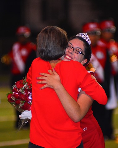 Mary Stewart, principal of Wyandotte High School, hugged Angelica Ponce after presenting her with the homecoming queen's crown during halftime of the football game with Atchison High School on Sept. 23. (Photo by Brian Turrel)