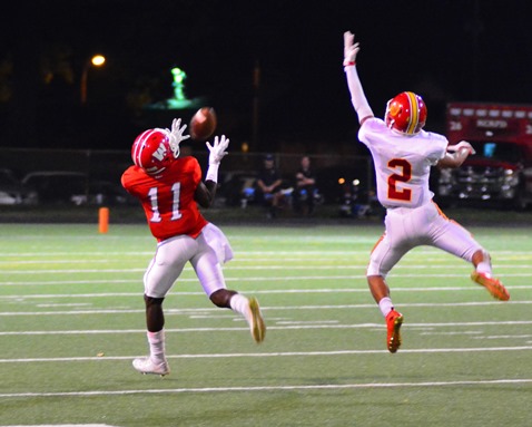 Wyandotte wide receiver GeRail Lucas (11) caught a pass over the outstretched arm of Atchison defensive back Tahj Helms during the second half of the football game between their schools on Sept. 23. (Photo by Brian Turrel) 