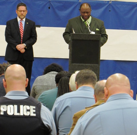 The Rev. Bob Milan Jr., right, offered a prayer as Mayor Mark Holland listened at tonight’s community forum on reducing violence. The meeting was at Schlagle High School. (Staff photo by Mary Rupert)