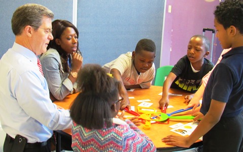 Gov. Sam Brownback, left, participated in activities with young students Thursday at the Boys and Girls Club in Kansas City, Kan. (Staff photo)