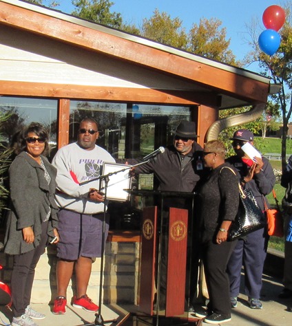 Wendell Maddox, chairman of the KCKCC Board of Trustees, center, wearing a hat, read a resolution from the board and presented it to Flunder's family on Saturday at KCKCC. (Staff photo)