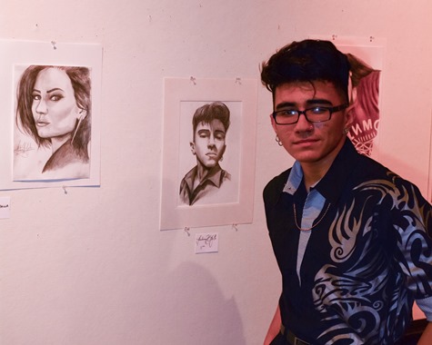 Bishop Ward student Abraham Ayalla posed with some of his drawings at the Bishop Ward Art Show. (Photo by Brian Turrel)