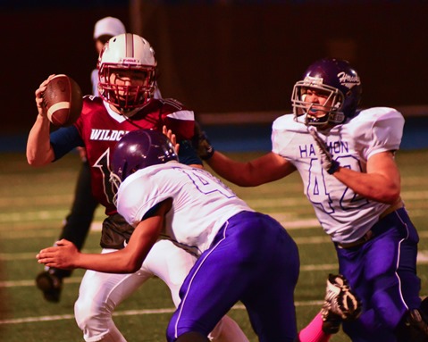 Harmon defensive lineman Dallas McKinley (40) sacked Washington quarterback Alex Howard (16) in the second quarter, assisted by Cordell Meeks (42). (Photo by Brian Turrel)