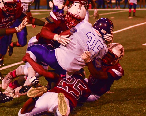 Washington defensive lineman Isaiah Vigil (56) made a tackle on Harmon running back Dre'Vontae Tiller (35) assisted by Guei Ware (3) and London Williams (25). (Photo by Brian Turrel)