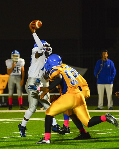 Sumner sophomore quarterback Nahshon Houston (10) released a throw just before taking a hit from Schlagle junior defensive linemen James Hampton (50) and Miles Davis (58) in the third quarter. (Photo by Brian Turrel)