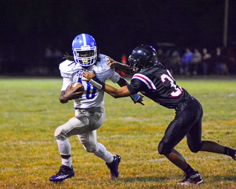 Sumner sophomore quarterback Nahshon Houston (10) slipped the tackle of a Bishop Ward defender during the third quarter.  The broken play included a fumble by Houston, who recovered to run the ball in for a touchdown. (Photo by Brian Turrel)