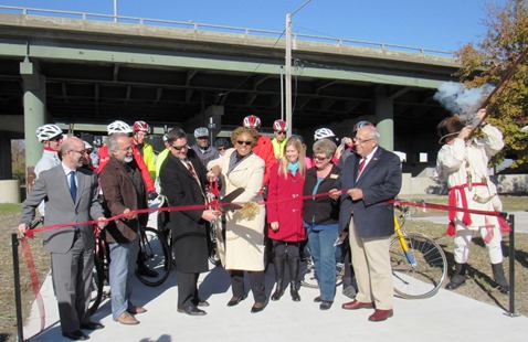 The ribbon for the Kaw Point Park Connector Trail was cut today by Mayor Mark Holland and UG Commissioner Gayle Townsend.  Also in the group were UG Commissioner Melissa Bynum, Darby Trotter  and Shari Wilson. The Friends of the Kaw's Mike Calwell fired a shot into the air. (Staff photo by Mary Rupert)