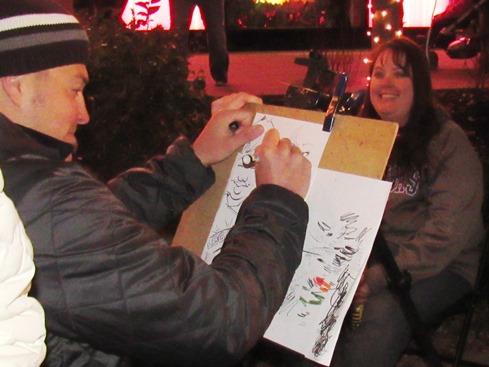 An artist drew caricatures of visitors to the holiday lighting ceremony tonight at the Legends Outlets in Kansas City, Kan. (Staff photo by Mary Rupert)