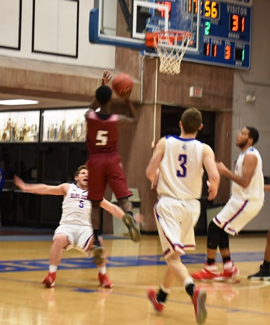  KCKCC guard Kellen Turner is sent sprawling as he takes a charging foul from Wentworth’s Quoyai Shorter in the Blue Devils’ 77-55 win Wednesday while KCKCC defenders Lane Hartley (5) and Donald Metoyer (40) look on. (KCKCC photo by Alan Hoskins) 