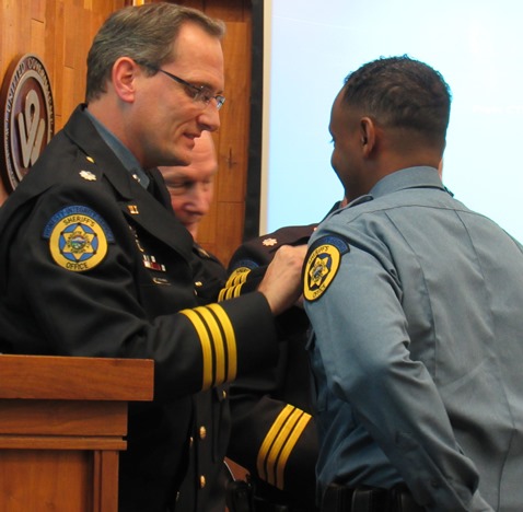 Jeffrey Fewell, administrator of the Wyandotte County Jail, with new graduates at a ceremony Dec. 15 at Kansas City, Kan., City Hall. (Staff photo by Mary Rupert) 